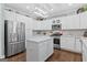 Bright kitchen features white cabinetry, stainless steel appliances, and an island with light countertops at 4780 Rambling Rose Dr, Cumming, GA 30040