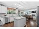 Spacious kitchen with white cabinets, stainless appliances, island, and hardwood floors open to the dining area at 4780 Rambling Rose Dr, Cumming, GA 30040