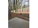 Wooded backyard with a small concrete patio and wooden privacy fence at 4328 Barcelona Trce, Stone Mountain, GA 30083