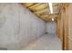 Unfinished basement showcasing exposed concrete walls, insulation, and ceiling pipes at 253 Edenwylde Ct, Hampton, GA 30228