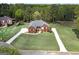 Aerial view of a well-manicured brick home with an expansive yard and mature trees showcasing its curb appeal at 253 Edenwylde Ct, Hampton, GA 30228