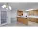 Open kitchen with wood cabinets, a breakfast bar, and views into the living room at 253 Edenwylde Ct, Hampton, GA 30228