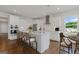 Modern white kitchen featuring a spacious island with seating and stainless steel appliances at 214 Kindness Cir, Mcdonough, GA 30252