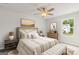 This primary bedroom features a queen bed, ceiling fan, bedside tables and an outside view at 214 Kindness Cir, Mcdonough, GA 30252