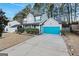 Two-story house with gray siding, blue garage door, and landscaping at 5735 Old Carriage Dr, South Fulton, GA 30349