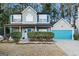 Charming two-story home with a manicured lawn, blue shutters, and a matching blue garage door at 5735 Old Carriage Dr, South Fulton, GA 30349