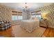 Charming bedroom with wood floors, patterned wallpaper, and a comfortable sitting area at 260 Lawrenceville St, Mcdonough, GA 30253