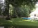 Beautifully landscaped backyard with sparkling in-ground pool and mature trees at 90 Barrington Grange Dr, Sharpsburg, GA 30277