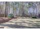 Wide backyard with green lawn, mature trees, storage shed, and privacy fence at 90 Barrington Grange Dr, Sharpsburg, GA 30277