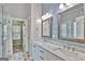 Bathroom featuring double sinks, marble countertops, glass shower and modern fixtures at 90 Barrington Grange Dr, Sharpsburg, GA 30277