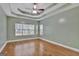 Spacious bedroom features a tray ceiling, ceiling fan, and natural light from multiple windows at 90 Barrington Grange Dr, Sharpsburg, GA 30277