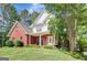Attractive home with a brick facade, welcoming front porch, and well-maintained landscaping at 90 Barrington Grange Dr, Sharpsburg, GA 30277