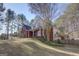 Two-story brick home, with a columned front porch and a well-maintained lawn surrounded by a wooded landscape at 90 Barrington Grange Dr, Sharpsburg, GA 30277