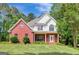 Charming two-story brick home featuring a well-maintained lawn and inviting front porch at 90 Barrington Grange Dr, Sharpsburg, GA 30277
