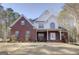 Classic two-story brick home featuring a covered front porch with white columns and well-maintained landscaping at 90 Barrington Grange Dr, Sharpsburg, GA 30277