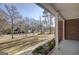 View from the front porch featuring brick columns, green landscape, and neighborhood street in the distance at 90 Barrington Grange Dr, Sharpsburg, GA 30277