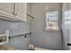 Functional laundry room with storage shelves and a bright window, making laundry tasks more enjoyable at 90 Barrington Grange Dr, Sharpsburg, GA 30277
