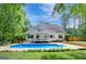 Backyard featuring an inviting pool, lush lawn, and manicured landscaping at 90 Barrington Grange Dr, Sharpsburg, GA 30277