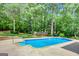 Outdoor in-ground swimming pool with concrete surround, diving board and lush green landscaping at 90 Barrington Grange Dr, Sharpsburg, GA 30277