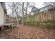 Backyard with wooden fence, stone wall, and leaves at 613 Mc Donald Se St, Atlanta, GA 30312