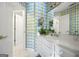 Bright bathroom with white vanity, checkered wallpaper, and a double sink at 295 Camden Creek Ct, Lawrenceville, GA 30043