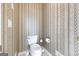 Small half bathroom with toilet and updated wallpaper at 295 Camden Creek Ct, Lawrenceville, GA 30043
