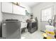 Bright laundry room with washer, dryer and storage cabinets at 295 Camden Creek Ct, Lawrenceville, GA 30043
