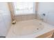Clean bathroom with an oval soaking tub and a window that offers natural light at 4937 Lower Elm St, South Fulton, GA 30349