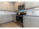 Modern kitchen with gray cabinets, granite countertops, and stainless steel appliances at 4937 Lower Elm St, South Fulton, GA 30349