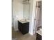 Bathroom featuring a single sink vanity, mirror, and doorway leading to another room at 284 Madison Grace Ave, Mcdonough, GA 30252