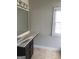 Bathroom featuring tile floors, dark vanity, light countertops, and a mirror with accent lighting at 284 Madison Grace Ave, Mcdonough, GA 30252