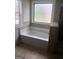 Bathroom with a soaking tub set under a bright window and accented with tiled features at 284 Madison Grace Ave, Mcdonough, GA 30252