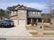 Attractive two-story home with a stone and siding facade, attached garage and a police vehicle in the driveway at 284 Madison Grace Ave, Mcdonough, GA 30252