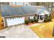 Aerial view of a brick home with an attached garage, landscaped bushes, and a spacious driveway at 1391 Lakeview Pkwy, Villa Rica, GA 30180