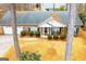 Aerial view of a brick home with mature trees, manicured landscaping, and a covered front porch at 1391 Lakeview Pkwy, Villa Rica, GA 30180