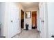 Hallway with neutral walls and carpet, featuring doors, a mirror, and a view into the bathroom at 1391 Lakeview Pkwy, Villa Rica, GA 30180