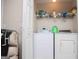 Laundry room with a washer, dryer, and shelving with cleaning supplies at 1391 Lakeview Pkwy, Villa Rica, GA 30180
