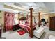 Spacious bedroom with a large four-poster bed and ensuite bathroom at 106 Old Gettysburg Way, Dallas, GA 30157