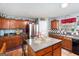 Kitchen with island, wood cabinets, and stainless steel appliances at 106 Old Gettysburg Way, Dallas, GA 30157