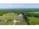 Expansive aerial shot showcasing a large property with green fields, barns, and lush trees at 3170 Double Bridges Rd, Rutledge, GA 30663