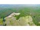 An aerial image of a large property with multiple fenced fields and lush, dense forests at 3170 Double Bridges Rd, Rutledge, GA 30663