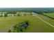 Aerial view featuring a pond with surrounding trees amid the property's sprawling green pastures at 3170 Double Bridges Rd, Rutledge, GA 30663