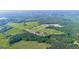 Expansive aerial view showcases sprawling greenery, interspersed with lush forest, trails, and buildings at 3170 Double Bridges Rd, Rutledge, GA 30663