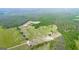 Aerial view of fenced pastures, barns, and a stately home nestled among mature trees at 3170 Double Bridges Rd, Rutledge, GA 30663