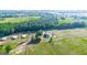 Aerial view showcases a home with outbuildings and fenced pastures, all nestled among green fields and trees at 3170 Double Bridges Rd, Rutledge, GA 30663