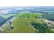 Aerial view displays large green pastures, interspersed with forests, outbuildings, and long dirt roads at 3170 Double Bridges Rd, Rutledge, GA 30663