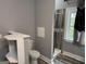 Bathroom with a toilet, shelving, and a shower featuring gray wood-look tiles at 1771 Ware Ave, East Point, GA 30344