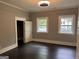 Bedroom with dark hardwood floors, two windows, and a closet at 1771 Ware Ave, East Point, GA 30344