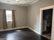 Bedroom with a window, dark floors, and a closet area visible through a doorway at 1771 Ware Ave, East Point, GA 30344