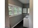 Bright laundry room with multiple windows, upper cabinets, and new appliances at 1771 Ware Ave, East Point, GA 30344